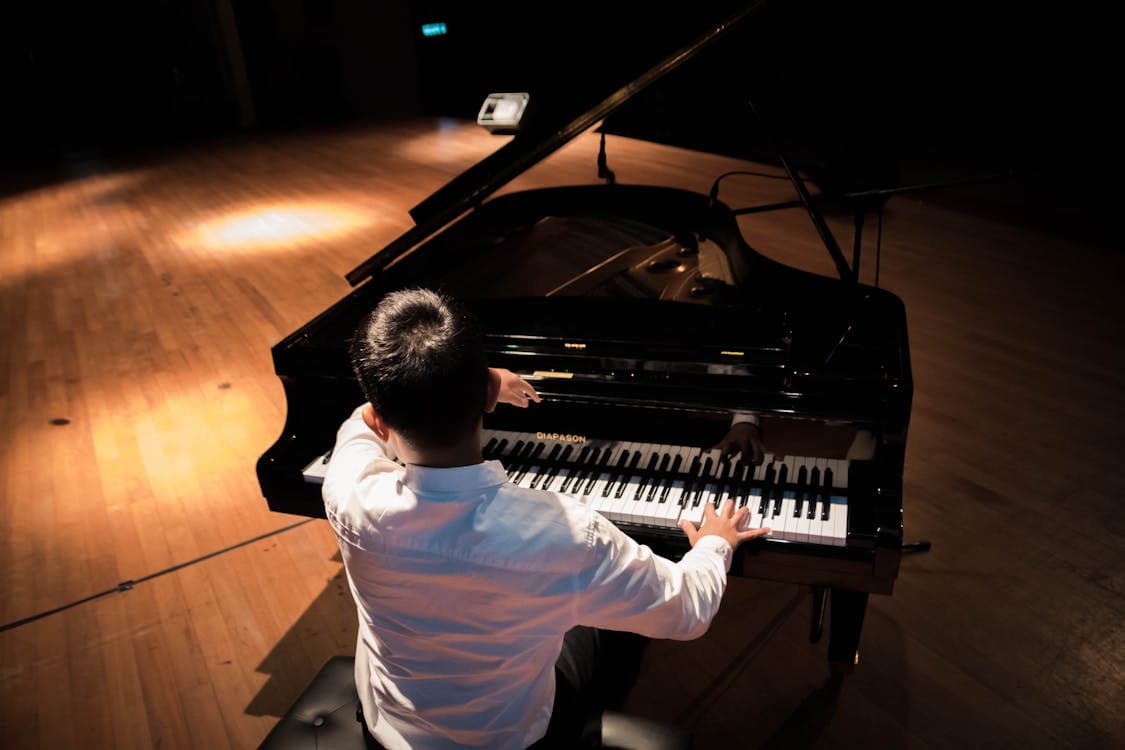 Pianist performing on stage under a spotlight